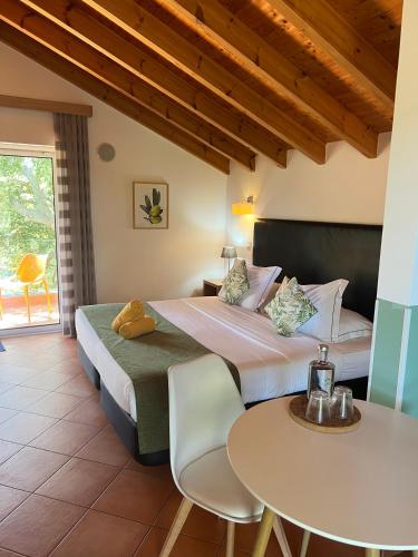 a bedroom with a bed and a table and chairs at VilaFoia in Monchique