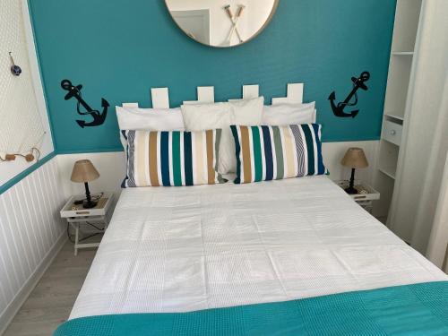 - une chambre avec un lit blanc et un miroir mural dans l'établissement Villa Ner Pensea à 250 m de la plage location samedi au samedi, à Saint-Gilles-Croix-de-Vie