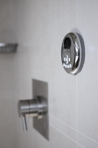 a bathroom with a soap dispenser on the wall at Bardessono Hotel and Spa in Yountville