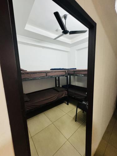 a room with a ceiling fan and bunk beds at AROMA INN in Kalpetta