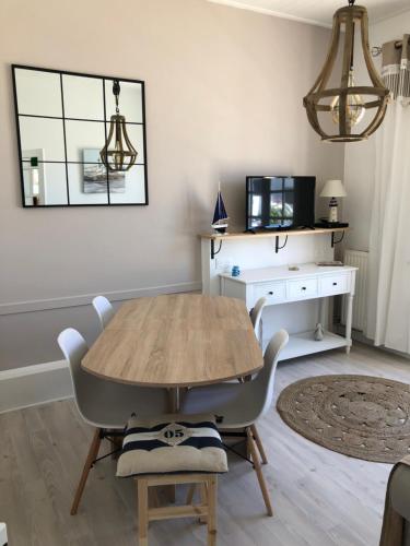 une salle à manger avec une table et des chaises en bois dans l'établissement Villa Ner Pensea à 250 m de la plage location samedi au samedi, à Saint-Gilles-Croix-de-Vie