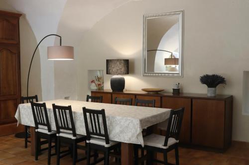 une salle à manger avec une table, des chaises et un miroir dans l'établissement Bastide Juliana, à Saint-Paul-Trois-Châteaux