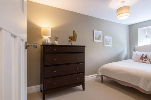 a bedroom with a bed and a dresser at Laburnum Cottage Lanchester- Escape Beyond Holiday Lets in Lanchester