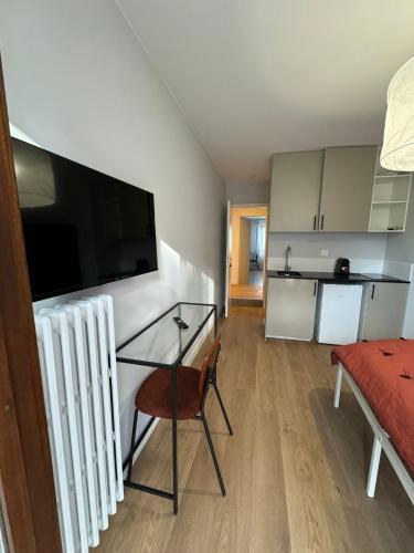 un salon avec une table en verre et une cuisine dans l'établissement M73 Marquer joli studio centre ville d'Annemasse, à Annemasse