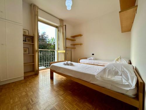 um quarto com uma cama e uma janela grande em Kibilù - Bright Apartment with Large Terrace near Station FN City Centre walking distance em Varese