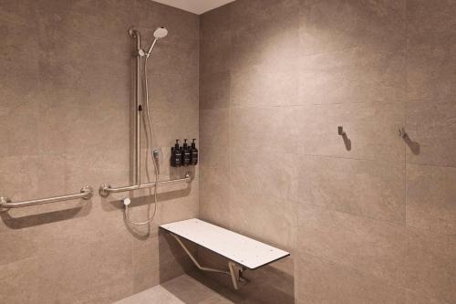 y baño con ducha y banco. en Rydges Hotel Port Macquarie, en Port Macquarie