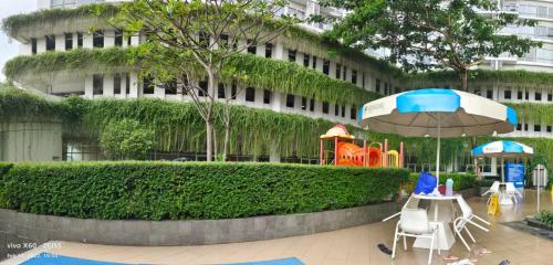 a table and chairs with an umbrella in front of a building at Altiz Bintaro Studio Exclusive 1 in Pondoklang