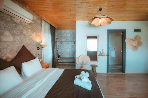 a bedroom with a bed with a teddy bear on it at Faralya Yoruk Evi Suite in Faralya