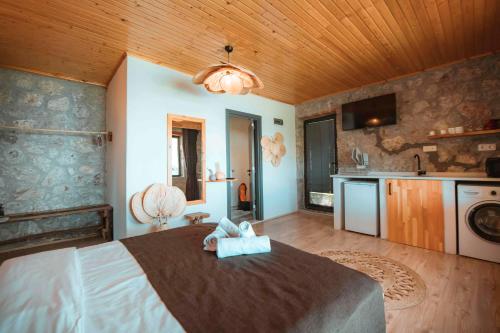 a bedroom with a large bed and a kitchen at Faralya Yoruk Evi Suite in Faralya
