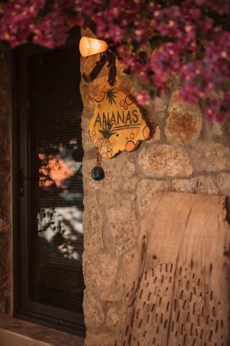 a butterfly sign on a stone wall with flowers at Faralya Yoruk Evi Suite in Faralya