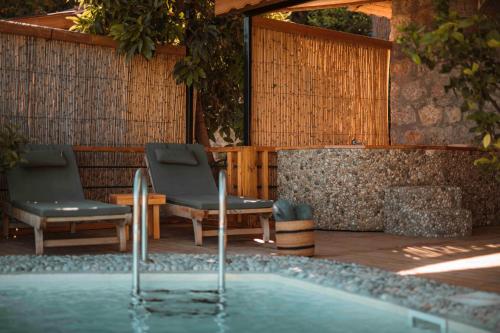 two chairs and a swimming pool in a yard at Faralya Yoruk Evi Suite in Faralya