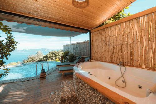 a bathroom with a tub and a view of the ocean at Faralya Yoruk Evi Suite in Faralya