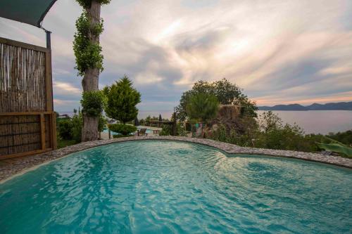 a large swimming pool with a view of the water at Faralya Yoruk Evi Suite in Faralya