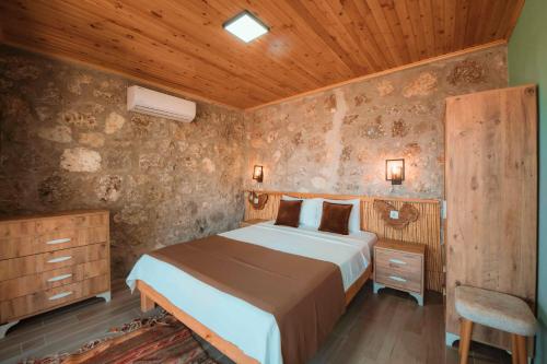 a bedroom with a bed and a wooden ceiling at Faralya Yoruk Evi Suite in Faralya