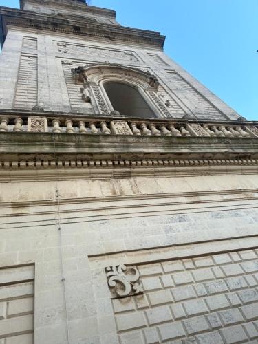 a tall tower with a clock on top of it at Palazzo Lanzilao's Rooms in Lecce