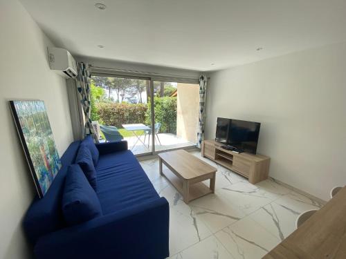 un salon avec un canapé bleu et une télévision dans l'établissement Appartement face mer et port Santa Lucia climatisé et wifi, à Saint-Raphaël