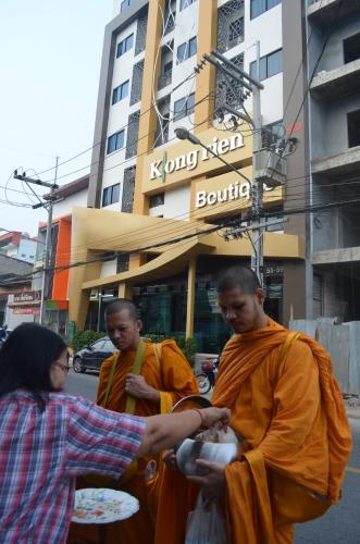 a group of three monks standing in the street at Klongrien Boutique Hotel in Hat Yai