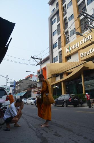 two monks standing in the street in a city at Klongrien Boutique Hotel in Hat Yai