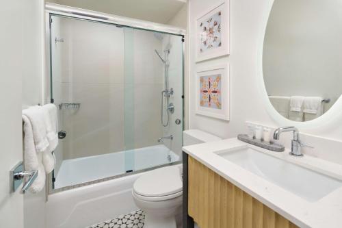 a bathroom with a shower and a toilet and a sink at OUTRIGGER Waikiki Paradise Hotel in Honolulu