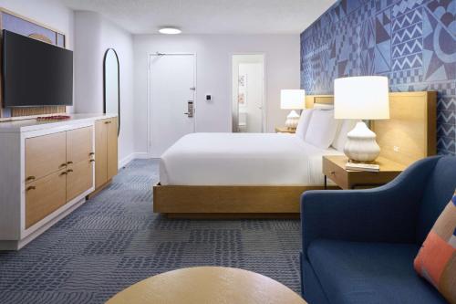 a hotel room with a bed and a couch at OUTRIGGER Waikiki Paradise Hotel in Honolulu