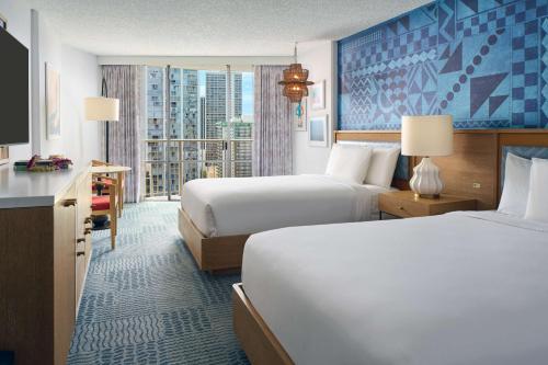 a hotel room with two beds and a window at OUTRIGGER Waikiki Paradise Hotel in Honolulu