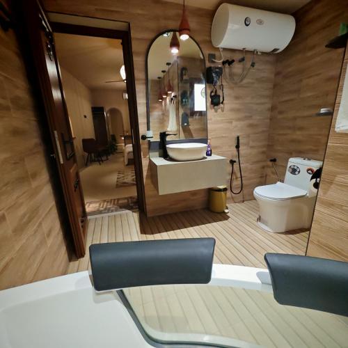 a bathroom with a sink and a toilet and a mirror at نزل عِطره Etra Inn in Nizwa