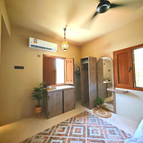 a kitchen with a refrigerator and a window at نزل عِطره Etra Inn in Nizwa
