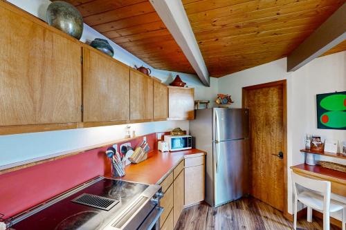 a kitchen with wooden cabinets and a stainless steel refrigerator at RiverPoint Retreat in Sandpoint