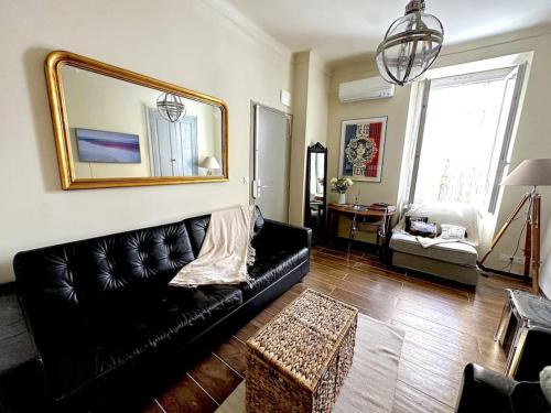 - un salon avec un canapé en cuir noir et un miroir dans l'établissement Chez Yaya, à Nice