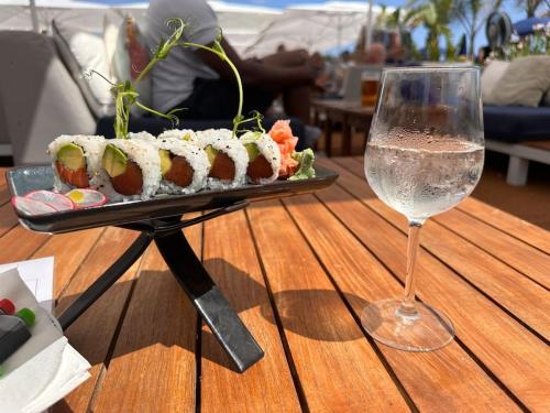 une assiette de sushi et un verre de vin sur une table dans l'établissement Chez Yaya, à Nice