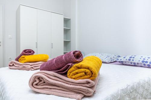 a pile of towels sitting on top of a bed at Apartmani Leo centar in Crikvenica