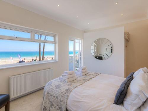 a bedroom with a bed with a view of the beach at Seaspray in St Ives