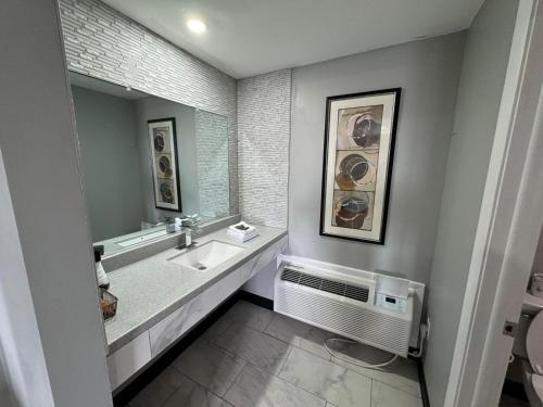 a bathroom with a sink and a mirror at Super 8 by Wyndham Hazleton in Hazleton