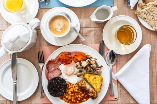 Un plato de comida con huevos, frijoles y café. en Dene House, en Great Yarmouth