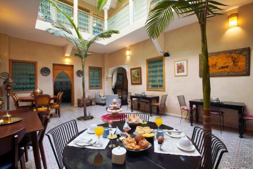 a dining room with a table with food on it at Riad Inaka in Marrakech