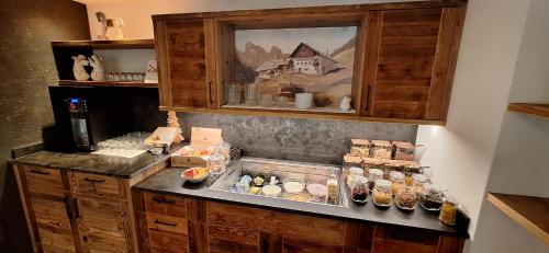 a kitchen with a counter with bottles of food at Garni Hotel Residence Diamant in San Vigilio Di Marebbe