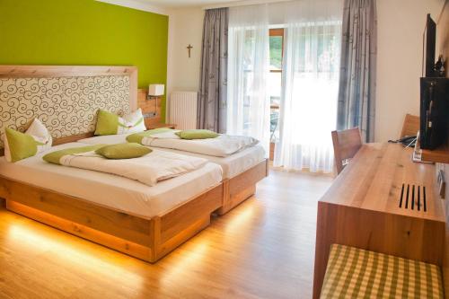 two beds in a room with green walls at Hotel am Wiesenhang - Garni in Bad Kohlgrub