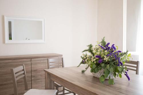 a dining room table with a vase of purple flowers at Il Colle affittacamere in Crespina