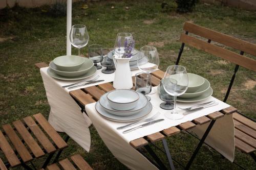 a table with plates and wine glasses on it at Il Colle affittacamere in Crespina