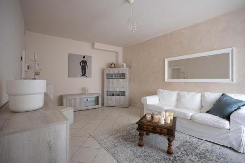 a living room with a white couch and a table at Il Colle affittacamere in Crespina