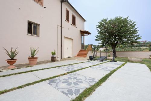 a house with a tile walkway in front of a house at Il Colle affittacamere in Crespina