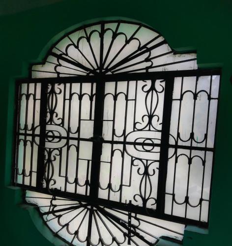 a black and white glass window on a green wall at Risabya Guest House in Gājol