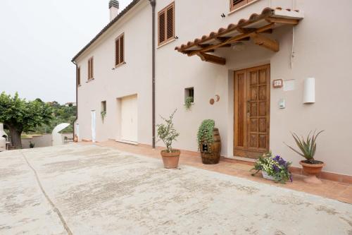 a courtyard of a white building with potted plants at Il Colle affittacamere in Crespina