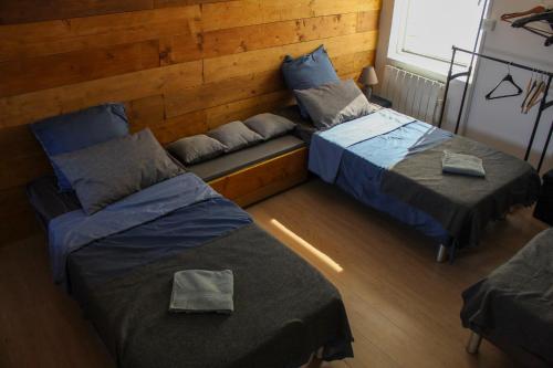 a room with two beds and a bench between them at La Briquette - WIFI - PARKING - Proche de Lille in Carvin