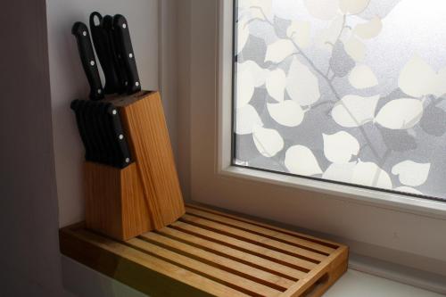 a wooden knife block sitting next to a window at La Briquette - WIFI - PARKING - Proche de Lille in Carvin