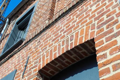 an opening in a brick building with a window at La Briquette - WIFI - PARKING - Proche de Lille in Carvin