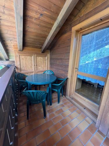 a patio with a table and chairs in a cabin at Appartamento Diamante - Ad un passo dalla Ciclabile in Auronzo di Cadore