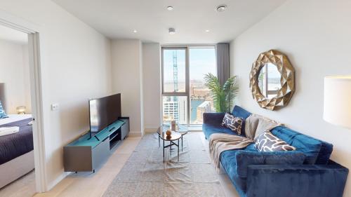 a living room with a blue couch and a television at Charles Hope Liverpool in Liverpool