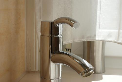 a bathroom sink with a chrome faucet next to a window at Hotel Altes Rathaus in Ostfildern
