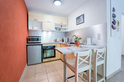 eine Küche mit einem Tisch und weißen Stühlen in der Unterkunft Montevrain disney 10mn Parking privé in Montévrain